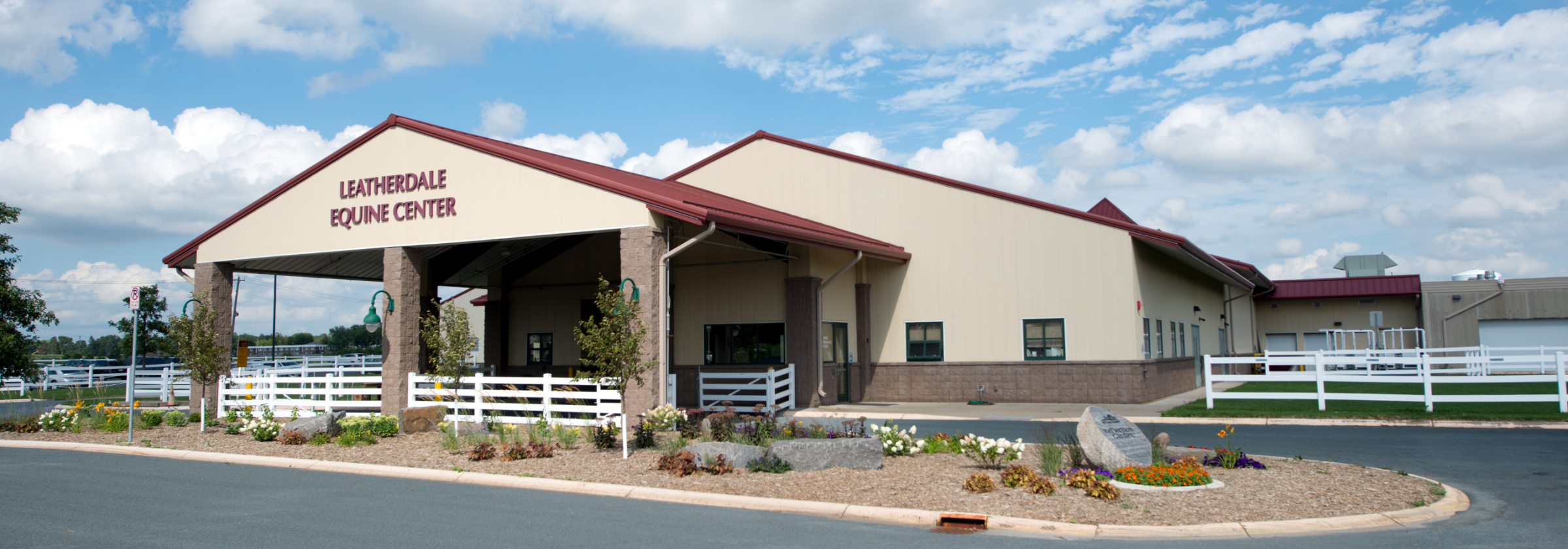 Leatherdale Equine Center building. Cream colored stucco building with maroon roof
