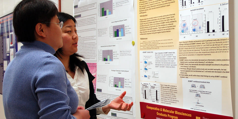 Graduate students reviewing a research poster