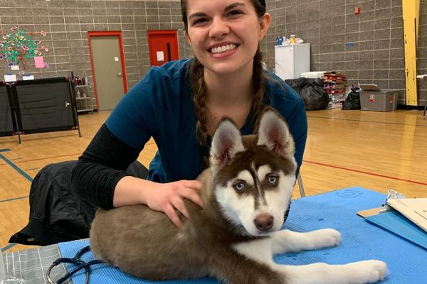 A student with a huskey puppy