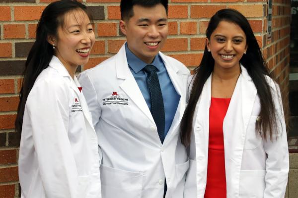 Whitecoat ceremony 2022 - students pose outside in front of brick wall